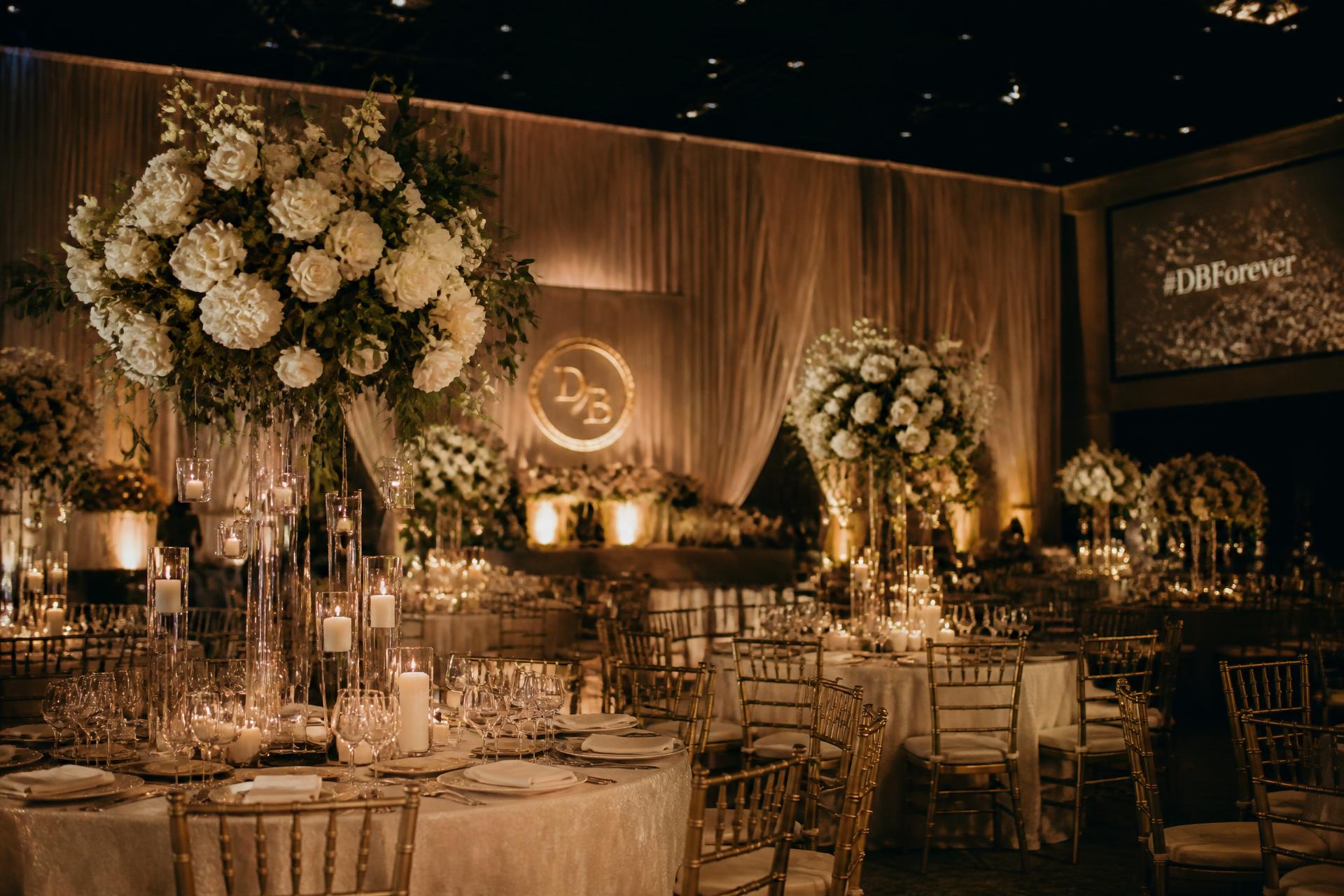 Elegantly decorated reception hall with candlelight and tall floral centrepieces